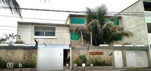 a building with a palm tree in front of it at Suítes felicidade Rio Centro in Rio de Janeiro