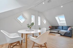 a living room with a table and white chairs at TotalApartments Skansegata Studio Apartments in Tromsø