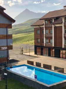 a hotel swimming pool with mountains in the background at GVC New Gudauri Loft-2 in Gudauri