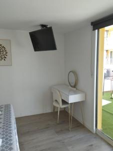 a bedroom with a desk and a tv on the wall at Hotel Serenity Platja d'Aro by Pandora Hoteles in Platja d'Aro
