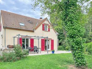 a house with red doors and a patio at Nature et Bord d'Etang à Jars in Jars