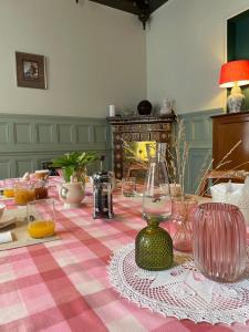 a table with a pink and white checkered table cloth at Le Clos de l'Ecu in Romorantin
