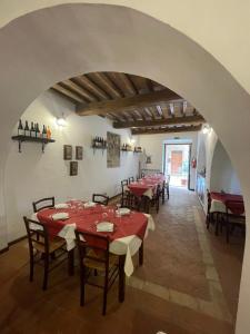 a dining room with tables and chairs and an archway at Locanda Francescana in Valfabbrica