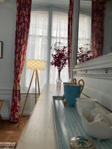 a kitchen with a table with a vase and a window at Le Clos de l'Ecu in Romorantin