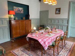 a dining room with a table with a red and white table cloth at Le Clos de l'Ecu in Romorantin