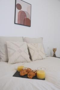 - un plateau de nourriture sur un lit avec deux verres de jus d'orange dans l'établissement La Chambre Tantra, à Wahlbach 4 autres photos