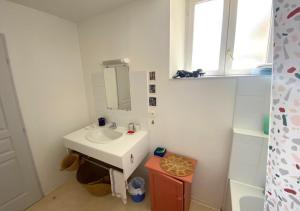 a white bathroom with a sink and a mirror at Chez Nellane - Poitiers - HyperCentre in Poitiers