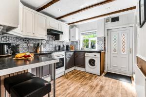 a kitchen with white cabinets and a washer and dryer at Modern 2-Bed Home Walk to Ashby Town Centre in Ashby de la Zouch +22 photos