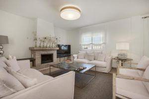 a living room with white furniture and a fireplace at Casa Cerezo - Chalet Lujo in Casabermeja