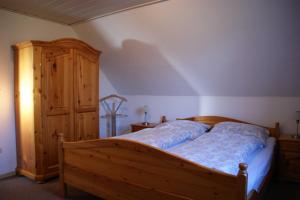 a bedroom with a wooden bed and a wooden cabinet at Ferienhaus Dollartbrise 45005 in Pogum