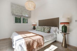 a white bedroom with a bed and a window at Casa Cerezo - Chalet Lujo in Casabermeja +28 photos