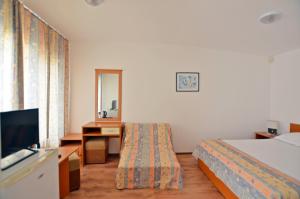 a hotel room with a bed and a television at Di Mare Holiday Village in Kranevo