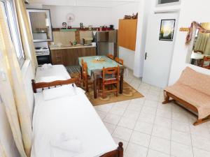 a room with two beds and a table and a kitchen at Studios Vaso in Limenaria