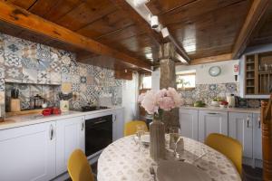 Una cocina con una mesa con un jarrón de flores encima. en 7 Virgin Street, St Ives, en St Ives