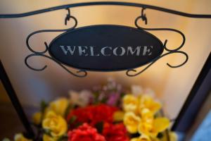 a sign with the word welcome above a bouquet of flowers at Hotel Cristallo in Malcesine