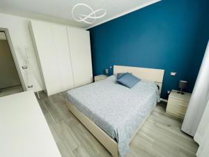 a blue bedroom with a bed and a blue wall at Maison Syrah in Aosta
