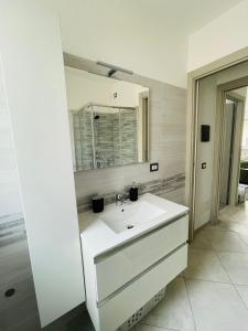 a white bathroom with a sink and a mirror at Maison Syrah in Aosta