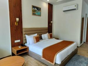 a hotel room with a large bed and a table at Creek Wood Resort Jim Corbett in Rāmnagar