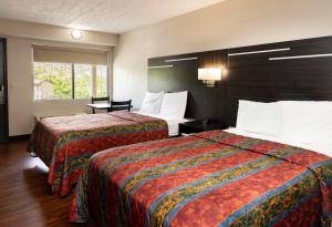 a hotel room with two beds and a window at Paragon Inn Hillsboro in Hillsboro
