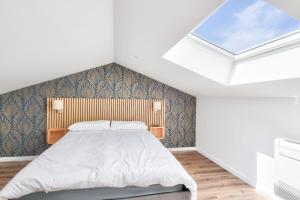 a bedroom with a bed in a room with skylights at Bel appartement - emplacement idéal in La Barre-de-Monts