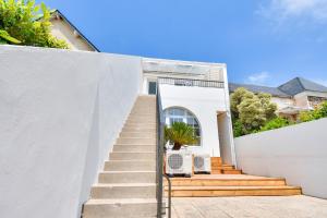 a stairway leading up to a white house at Bel appartement - emplacement idéal in La Barre-de-Monts