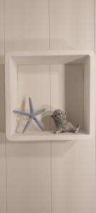 a white shelf with two toy figurines on it at Ferienwohnung Kleine Kegelrobbe (mit Pool) in Burhave