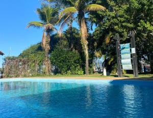 a swimming pool with palm trees in the background at Samba Angra dos Reis in Angra dos Reis