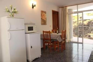 kuchnia z białą lodówką i stołem z krzesłami w obiekcie Cozy apartment in Puerto de Naos 45 m² mountain view w mieście Puerto Naos +12 zdjęć