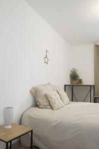 a white bedroom with a bed and a table at La Chambre Passionnée in Wahlbach