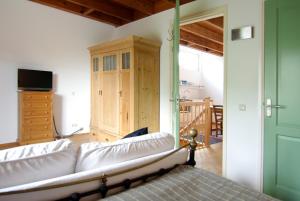 a living room with a white couch and a cabinet at Tranquil wooden house with free parking in Amsterdam