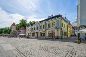 a cobblestone street with a yellow and blue building at Tallinn Old Town Romantic Apartment in Tallinn
