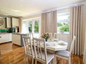 una cucina e una sala da pranzo con tavolo e sedie bianchi di Cedar Cottage a Norwich