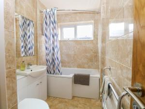 un bagno con vasca, lavandino e WC di Cedar Cottage a Norwich Altre 20 foto
