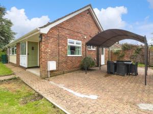 una casa di mattoni con un arco sopra un patio di Cedar Cottage a Norwich