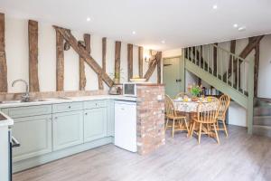 a kitchen and dining room with a table and chairs at Harvest Cottage Valley Farm Barns, Snape in Saxmundham