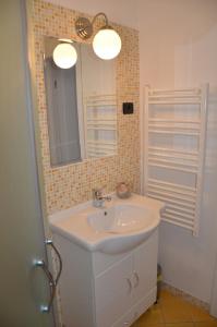 La salle de bains est pourvue d'un lavabo et d'un miroir. dans l'établissement Apartments Bertok, à Koper