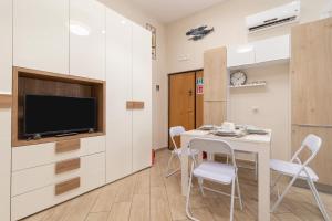 a room with a table and chairs and a tv at Zelda Casa Vacanza in Giovinazzo