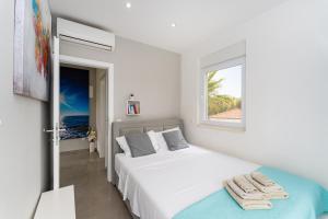 ein weißes Schlafzimmer mit einem Bett und einem Fenster in der Unterkunft Villa Diana in Zaton bei Nin in Zaton + 56 Fotos