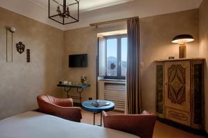 a room with a bed and chairs and a window at San Francesco al Monte in Naples