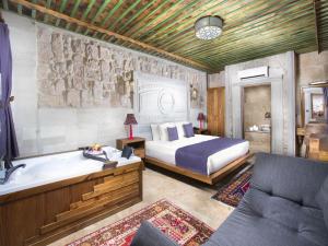 a bedroom with a king sized bed and a bath tub at Rapsodi Cappadocia in Göreme