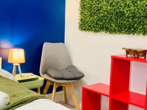 a bedroom with a chair next to a bed at Le repaire des héros 150m plage parking privé - lesvoyagescolorés in Saint-Valéry-en-Caux