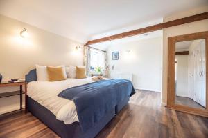 a bedroom with a large bed and a window at The Stables Valley Farm Barns, Snape in Saxmundham
