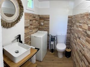 a bathroom with a white toilet and a sink at Villa Alva in Sikia +22 photos