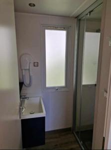 a bathroom with a sink and a window and a shower at Camping Valras plage 5 étoiles in Vendres-Plage