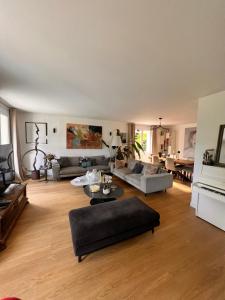 a living room with a couch and a table at Villa proche Paris et Versailles in Orgeval