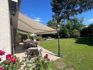 a patio with a table and a street light at Villa proche Paris et Versailles in Orgeval