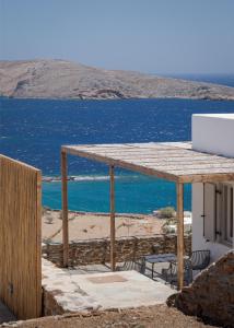 a table with chairs and a laptop on a beach at Kythea Suites Kythnos in Kithnos