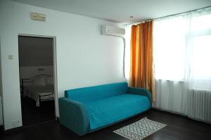 a blue couch in a room with a bedroom at Casa Yuppy Du in Eşelniţa