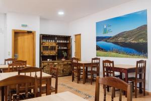 Una habitación con mesas y sillas y un gran cuadro en la pared. en Vila Vilariño Albergue Hotel & Restaurante, en Ourense
