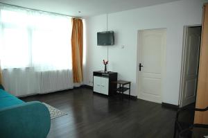 a living room with a blue couch and a television at Casa Yuppy Du in Eşelniţa